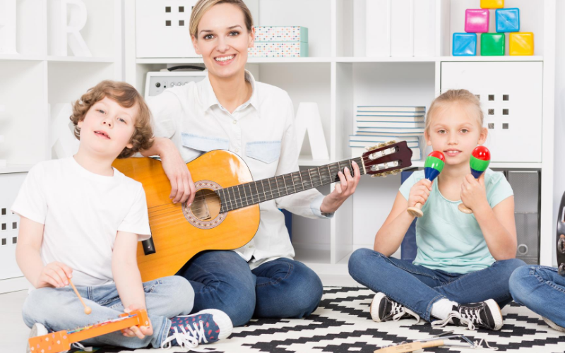 Kids in the homeschool with their mom, playing different musical instruments